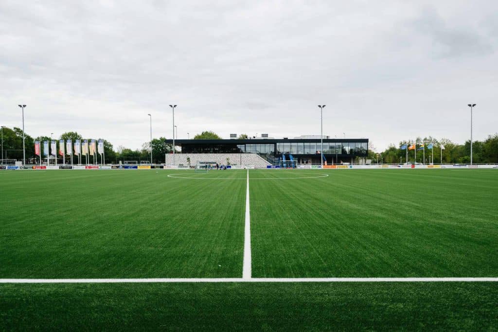 voetbalveld met in de verte sportaccommodatie